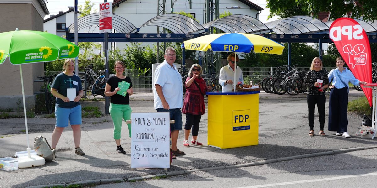Infostände des Grünen Ortsverbands Gilching, der FDP und der SPD am Bahnhof Gilching-Argelsried vor den überdachten Fahrrad-Abstellplätzen